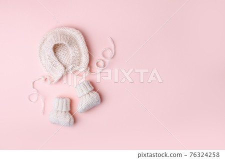 Pale pastel cute baby handknitted bonnet and booties socks. Set of kids clothes and accessories. Fashion newborn. Flat lay, top view. Handmade clothes, Girl baby shower, first birthday gifts 76324258