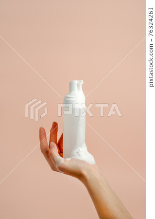 Woman hand press Pure white plastic pump bottle and other hand take cleaner foam, dispenser with antiseptic or antimicrobial soap. Healthcare, daily routine during pandemic covid-19 concept 76324261