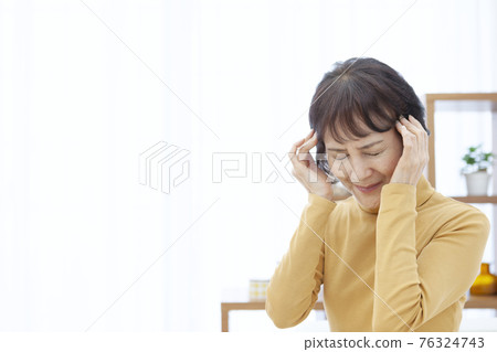 Senior woman holding temple 76324743