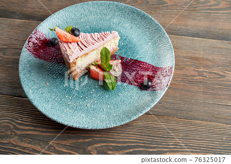 Cheesecake with berries on decorated plate. 76325017
