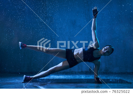 Wet woman practicing side plank exercise. Wet woman practicing side plank exercise. 76325022