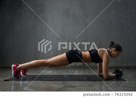Muscular woman doing plank exercise. Muscular woman doing plank exercise. 76325092