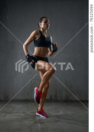Athletic wet woman running on spot. Athletic wet woman running on spot. 76325094