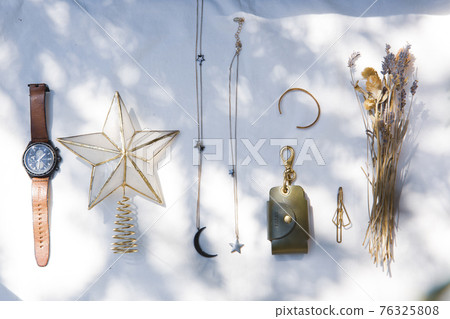 Frame of dried flowers and accessories placed on white fabric 76325808