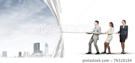 Young businesspeople working in collaboration and pulling white advertisement banner 76328184