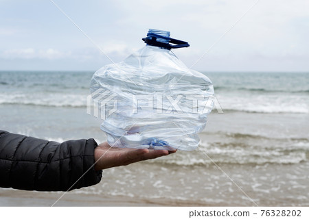 man with a used plastic bottle in his hand 76328202