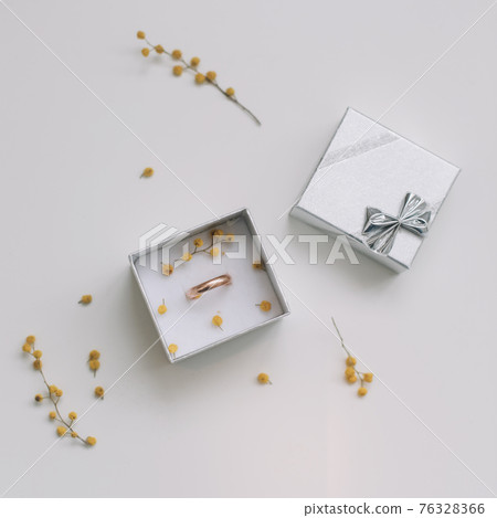Box with golden engagement ring on flowers background, top view. Wedding, Marriage proposal concept Box with golden engagement ring on flowers background, top view. Wedding, Marriage proposal concept 76328366