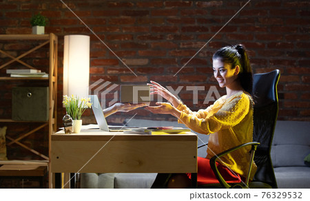 Young Caucasian woman talking with friend online through laptop. 76329532