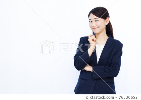 A business woman in her thirties who is lost with a smile A business woman in her thirties who is lost with a smile 76330652