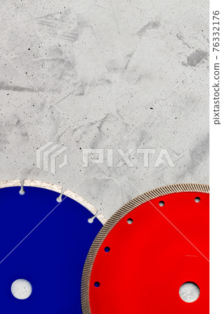 Blue and red diamond saw blades on a gray concrete background. Blue and red diamond saw blades on a gray concrete background. 76332176