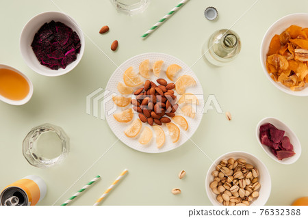 Dried fruits and nuts with sauce on green background with sunlight Dried fruits and nuts with sauce on green background with sunlight 76332388