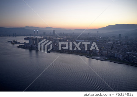 Aerial view of seaside town at sunset. 76334032