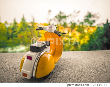background with old toy scooter in vintage Italian style background with old toy scooter in vintage Italian style 76334115