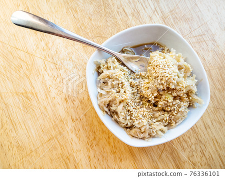 fork in grated kohlrabi salad with sesame seeds 76336101