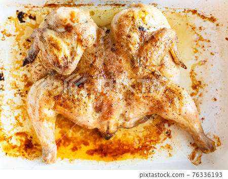 flattened fried chicken tabaka in white baked dish flattened fried chicken tabaka in white baked dish 76336193