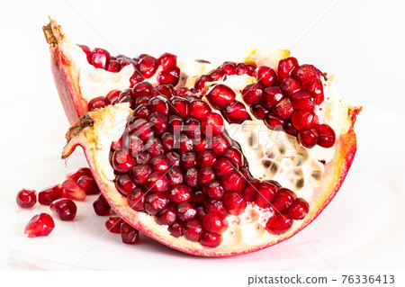 splitted pomegranate fruit on plate on white 76336413