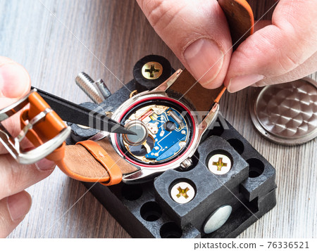 watchmaker repairs quartz wristwatch close up 76336521