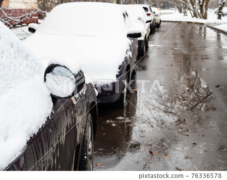 the first snow on cars parked along wet city road the first snow on cars parked along wet city road 76336578