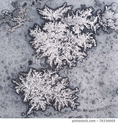 frozen snowflakes on window pane close up 76336669