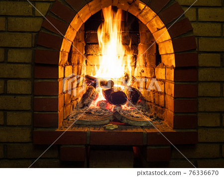 front view of burning woods in fireplace 76336670