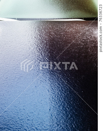 ice-covered hood of dark blue car close up ice-covered hood of dark blue car close up 76336723