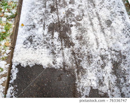 asphalt path partially cleared of ice in city park asphalt path partially cleared of ice in city park 76336747