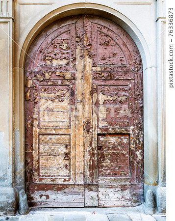 old shabby wooden door in Bergamo town 76336873