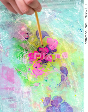 mixing of dyes on surface of liquid in basin mixing of dyes on surface of liquid in basin 76337105