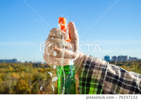 spraying the detergent on glass spraying the detergent on glass 76337132
