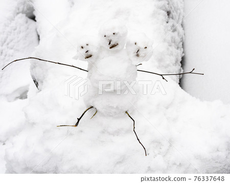 little three-headed snowman on snowy fallen tree little three-headed snowman on snowy fallen tree 76337648