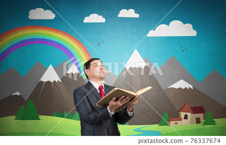 Happy businessman holding open book Happy businessman holding open book 76337674