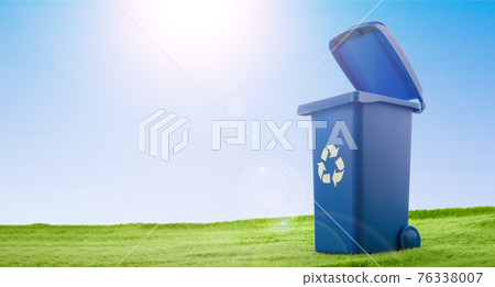 A plastic blue container stands on green grass against blue sky. A plastic blue container stands on green grass against blue sky. 76338007