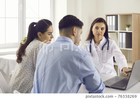 Medical doctor showing diagnosis results to patients on laptop screen in office Medical doctor showing diagnosis results to patients on laptop screen in office 76338269