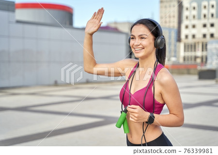 Attractive lady using skipping rope and wireless headphones during training Attractive lady using skipping rope and wireless headphones during training 76339981