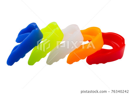 many multi-colored boxing mouth guards, lie in a row, on a white background many multi-colored boxing mouth guards, lie in a row, on a white background 76340242