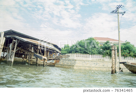 A slum poor people's construciton next to a luxurious villa in Bangkok, Thailand. Retro capture on film demonstrating social inequality. A slum poor people's construciton next to a luxurious villa in Bangkok, Thailand. Retro capture on film demonstrating social inequality. 76341465