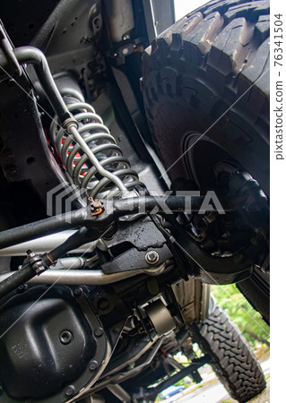 Off-road car chassis with a detailed view of the coil spring at the front wheel. Off-road car chassis with a detailed view of the coil spring at the front wheel. 76341504