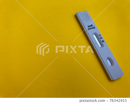 medical procedures. coronavirus test on a bright yellow background. new home self-diagnosis kit. sensitive test strip for taking blood and determining antibodies 76342915