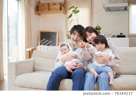 Asian family watching TV together Asian family watching TV together 76344237