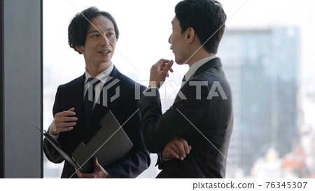 Businessman standing and talking 76345307