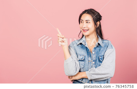 woman standing smiling indicate finger empty space 76345758
