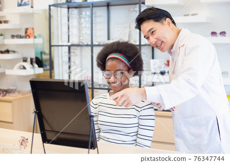 man professional optician selling and young woman african american choosing spectacles glasses. man professional optician selling and young woman african american choosing spectacles glasses. 76347744