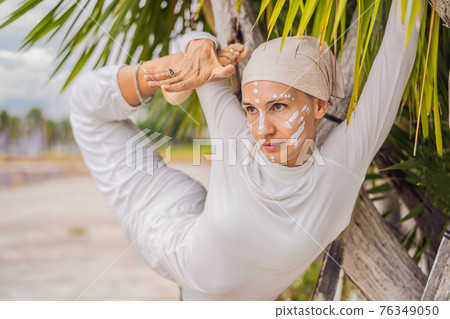 Kundalini yoga woman in white clothes and turban practices yoga kundalini on the background of the sea, mountains and sunset. Fighting face painting of the Indians shows her inner world. Visual Kundalini yoga woman in white clothes and turban practices yoga kundalini on the background of the sea, mountains and sunset. Fighting face painting of the Indians shows her inner world. Visual 76349050