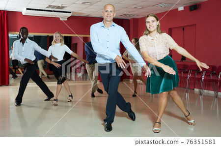 Young positive people dancing twist together at modern dance studio 76351581