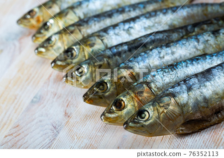 Salted and pressed sardines on wooden table Salted and pressed sardines on wooden table 76352113