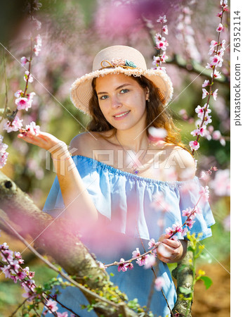 Woman in straw hat enjoying the nature in spring Woman in straw hat enjoying the nature in spring 76352114