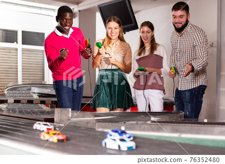 Portrait of friends with slot car racing game Portrait of friends with slot car racing game 76352480