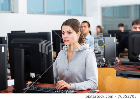 Female and male students working on computers 76352705