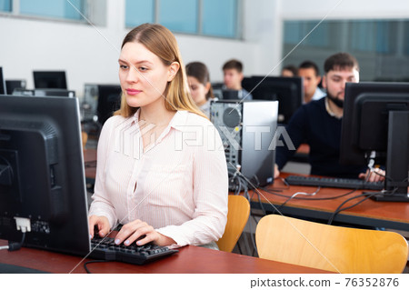 Portrait of female and male students working on computers in classroom Portrait of female and male students working on computers in classroom 76352876