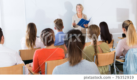 Students listening to lecture of female teacher Students listening to lecture of female teacher 76352919